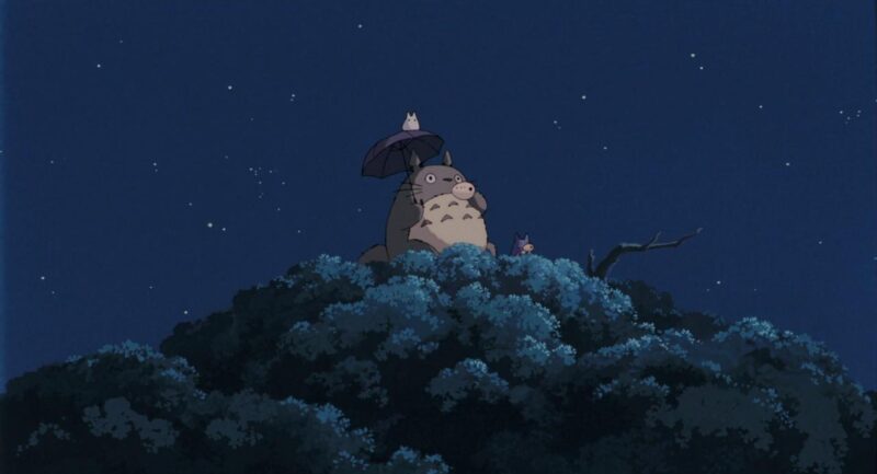 Totoro and other forest spirits stand atop a tree while playing ocarinas