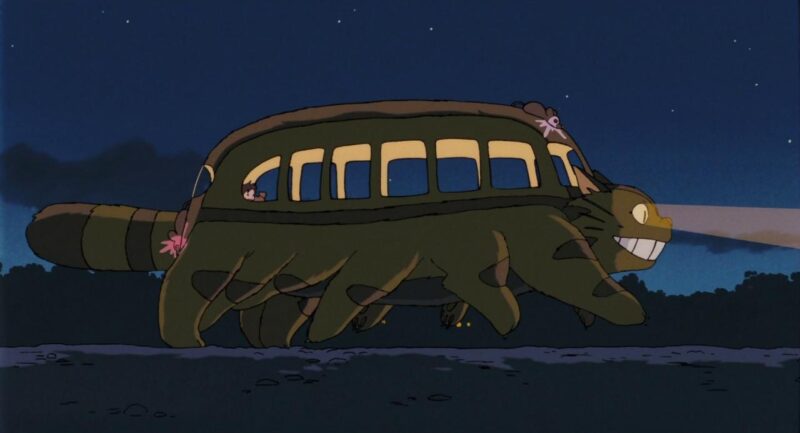 The Catbus runs through fields while carrying Satsuki and Mei
