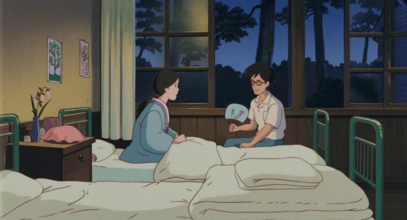 Yasuko sits in a hospital bed and talks to Tatsuo