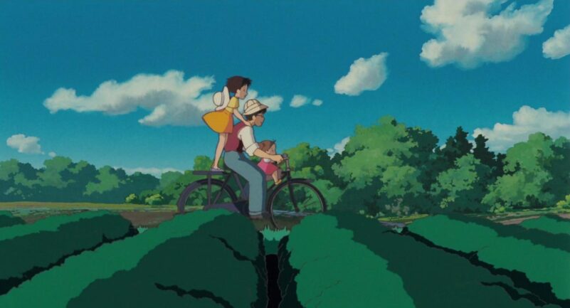 Tatsuo rides on a bike with his daughters Satsuki and Mei