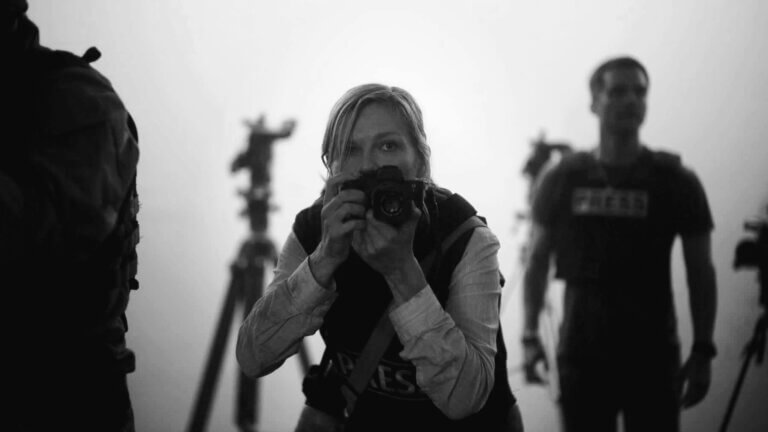 A war photographer raises her camera