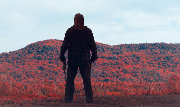 Johnny stands at the cliff after dispatching the yoga girl and looks at the hills