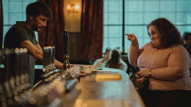 Donny stands behind the bar while he talks to Martha, who points at him