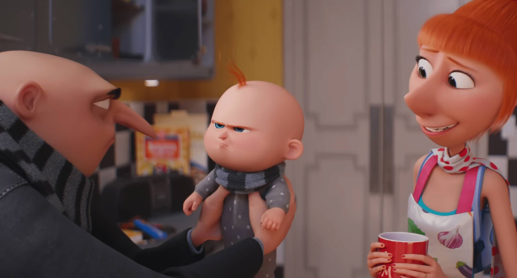 Gru holds Gru Jr. who looks upset while Lucy awkwardly smiles