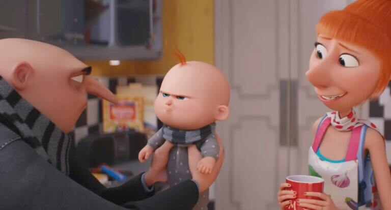 Gru holds Gru Jr. who looks upset while Lucy awkwardly smiles