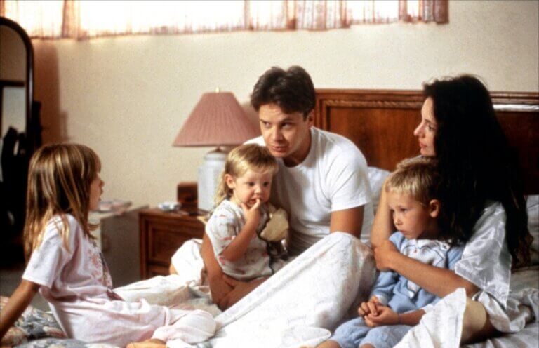 Gene Shepard and his wife Sherri sit with their children in bed