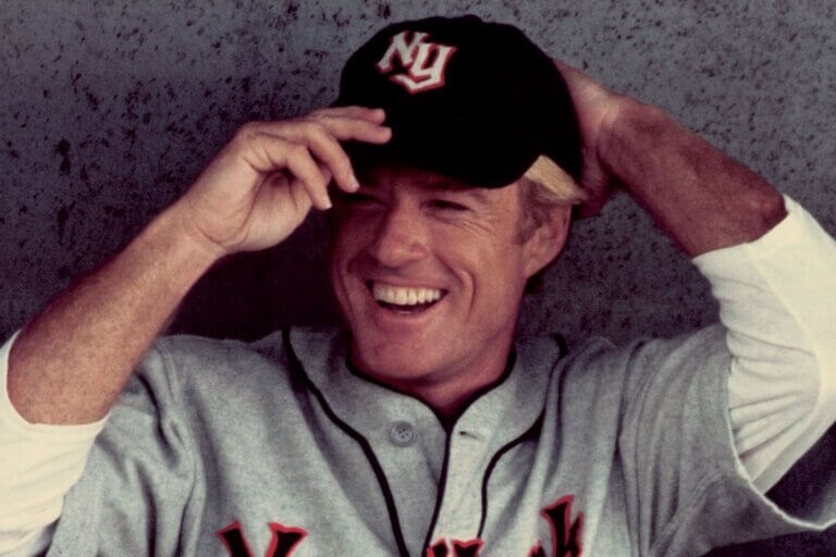 Roy Hobbs adjusts his baseball cap in the dugout