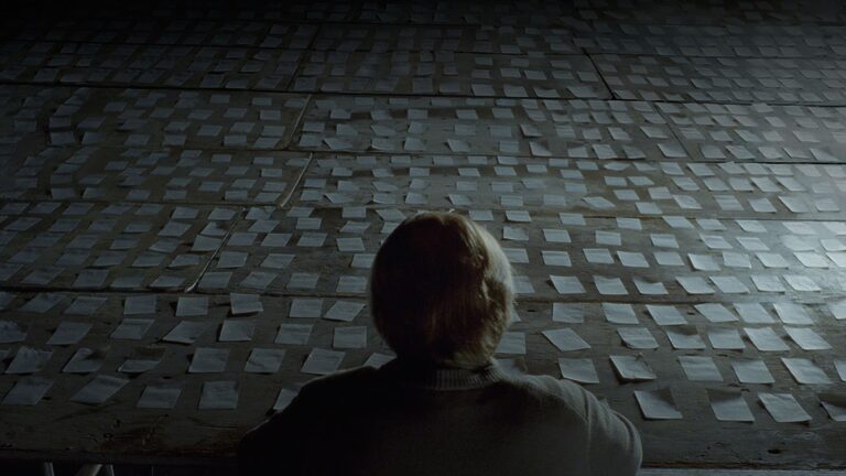 Caden looks at a hundreds of sticky notes on the ground