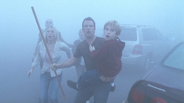 a man holding a child in his arms in the mist