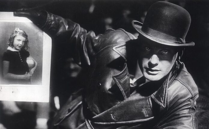 A man holds up a photo of a little girl