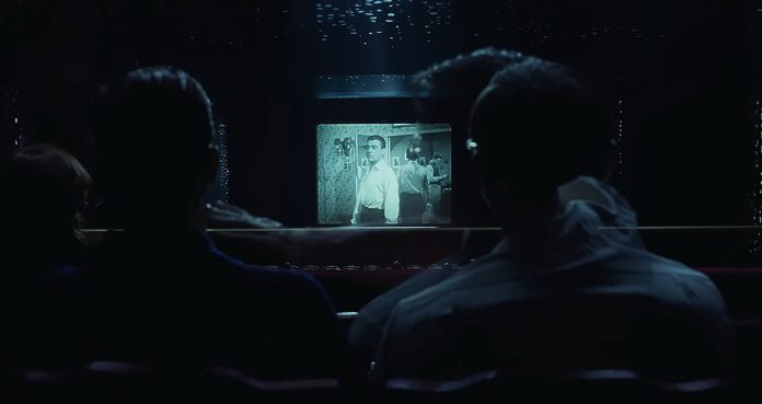 Two men watch a movie in a theater