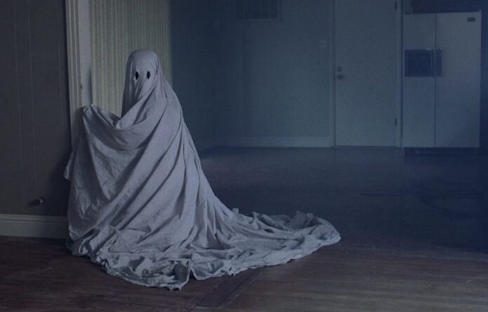 A ghost in a white sheet in an empty house