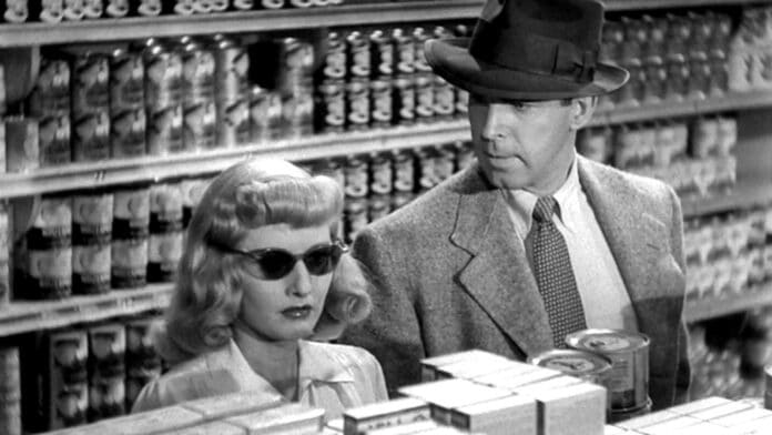 Phyllis and Walter stand together in a grocery store in the film noir Double Indemnity