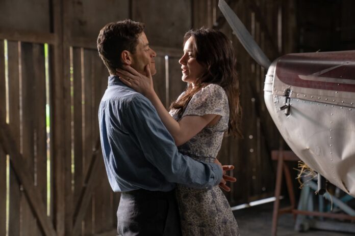 A man and woman hug in a barn.